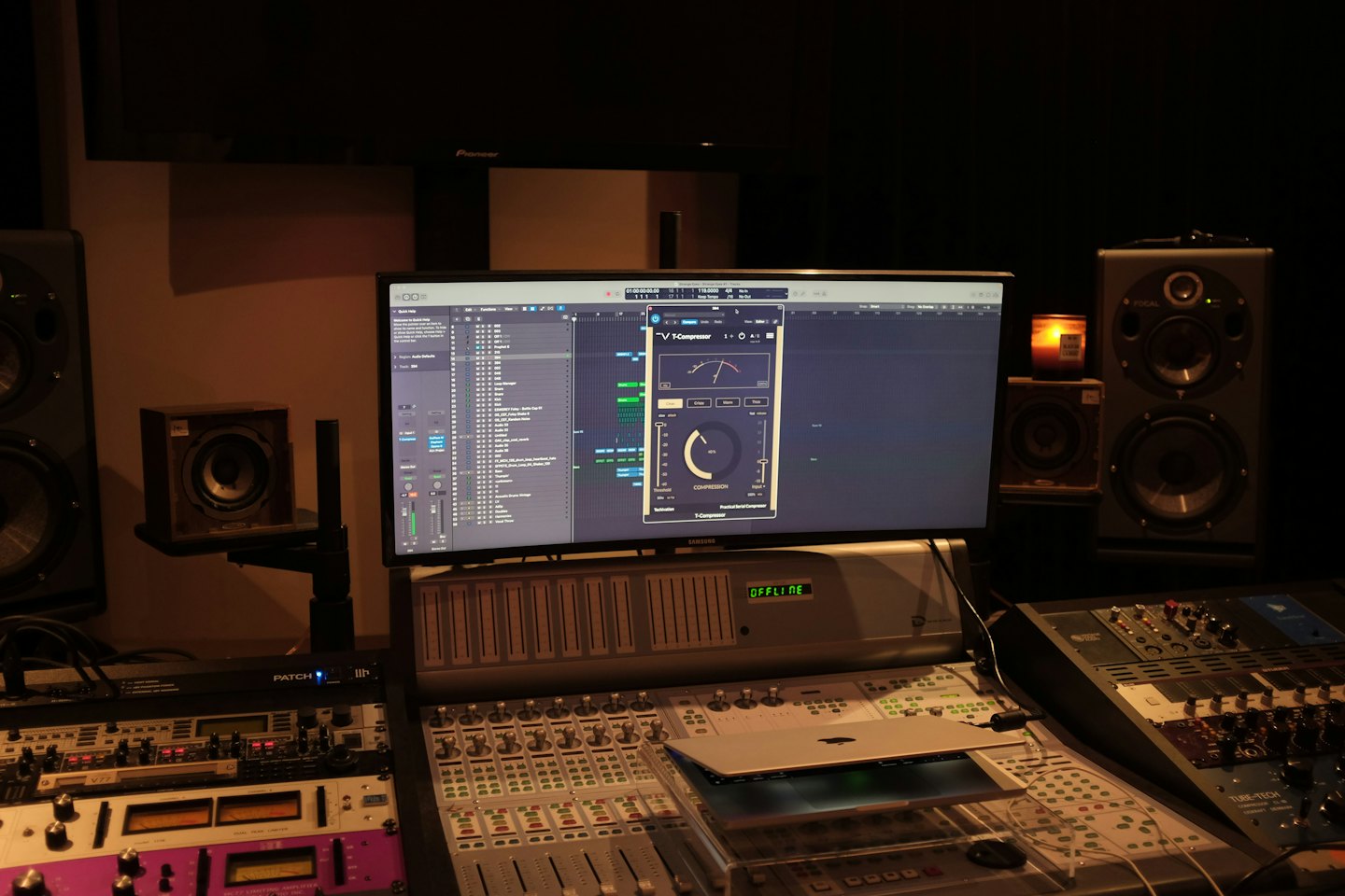 Recording studio control room with mixing consoles and computer screen.