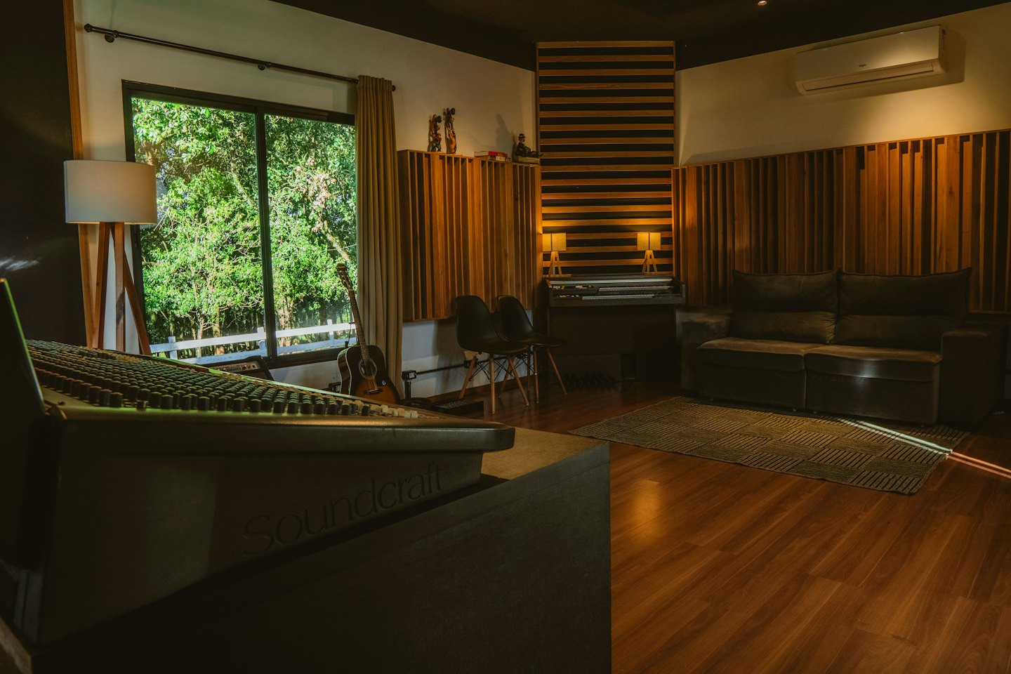 Music recording studio with mixing console and acoustic panels.